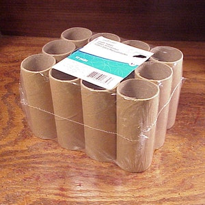 May include: A pack of 12 brown cardboard tubes, wrapped in clear plastic. The tubes are arranged in a rectangular shape. The pack is labelled "Craft Tubes - Cardboard Tubes for Crafts & Manufacturing".