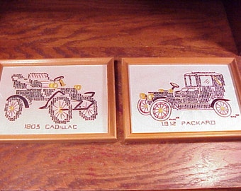 1970's Vintage Pair of Vintage Framed Cross Stitch Depiction of Antique Cars, a 1903 Cadillac and a 1912 Packard, in Wooden Frames, Old