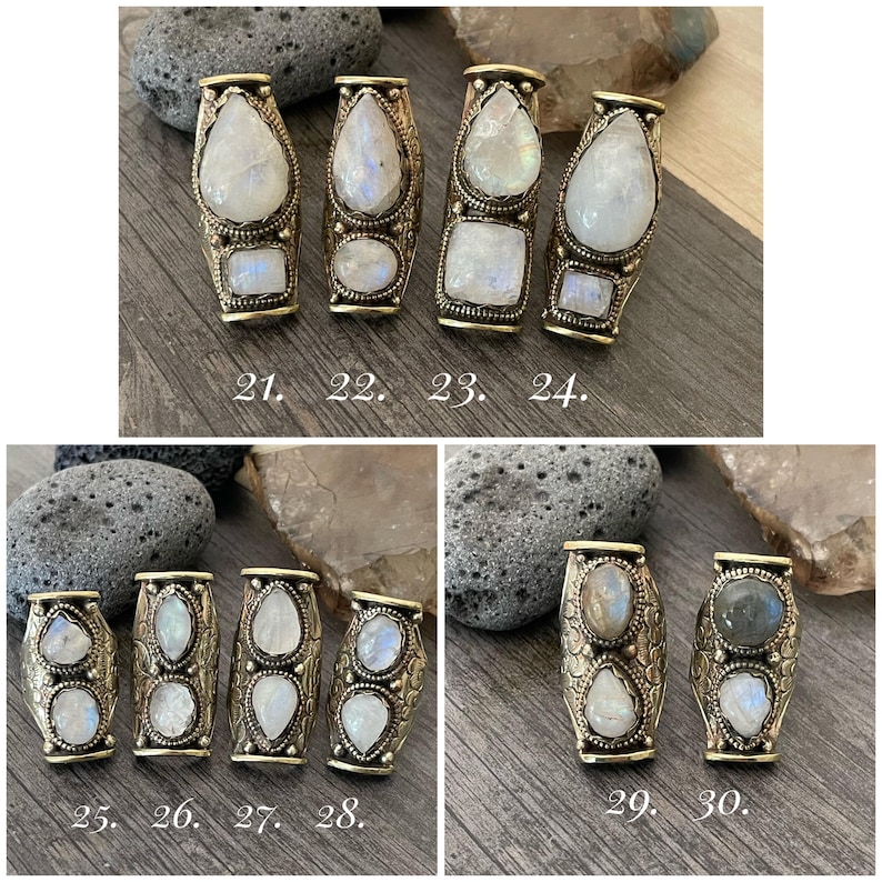 May include: Ten silver rings with moonstone settings. Each ring has a different design and features a unique moonstone. The rings are numbered 21 through 30.