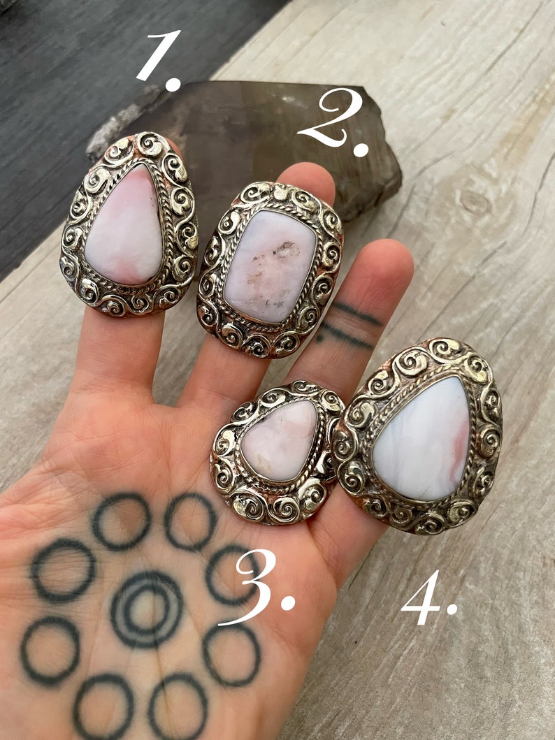 May include: Four silver rings with pink stones set in ornate designs. The rings are numbered 1 through 4.