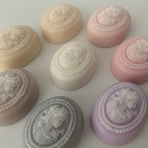 An oval mini soap featuring the illustration of a sophisticated woman facing in one direction, rendered in soft pastel colors of your choice with white highlights that enhance her elegance and charm.