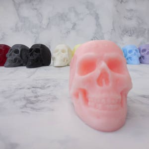 A row of 10 skull soaps in the background with a peach skull up front for close up image