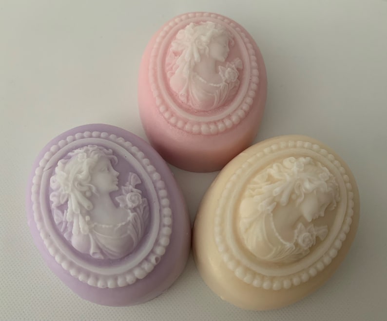 An oval mini soap featuring the illustration of a sophisticated woman facing in one direction, rendered in soft pastel colors of your choice with white highlights that enhance her elegance and charm.