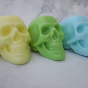 Close up of yellow, green, blue green and blue pastel skull soaps