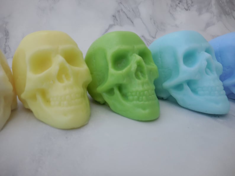 Close up of yellow, green, blue green and blue pastel skull soaps