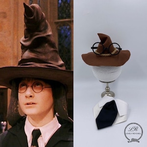 May include: A brown pointed hat with a rope band, black round-rimmed glasses, and a white collared shirt with a black necktie. The set includes a logo with the text Lovely Reychell. The items are displayed on a white spherical stand.