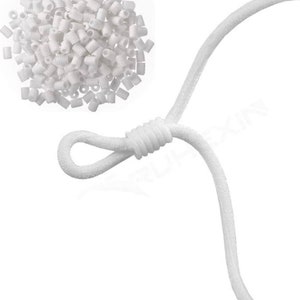 May include: A collection of small, white plastic cord adjusters and a white elastic cord. The adjusters are cylindrical with a hole through the center. The elastic cord is looped and knotted, designed for face masks or similar items.