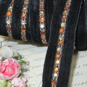 May include: Black velvet ribbon trim with a row of gold and orange rhinestones.
