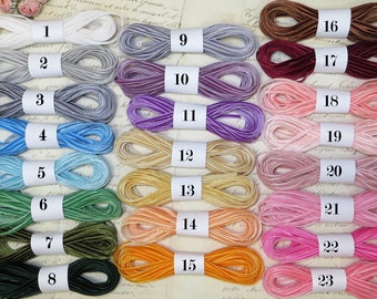 May include: Twenty-three spools of velvet ribbon in various colors, numbered 1 through 23. The ribbon is arranged in rows, with each spool labeled with a number.