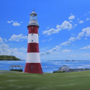 Puede incluir: Un faro rojo y blanco a rayas se alza alto contra un cielo azul con nubes blancas. El faro está en una colina cubierta de hierba con vistas a una masa de agua.