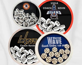 Könnte beinhalten: Vier runde Behälter mit schwarzen Deckeln und weißen Böden. Jeder Behälter hat ein anderes Teamlogo und Namen von Spielern. Die Logos sind für die Northeast Generals, die Wooster Oilers, die Lakers und die Warren Wave. Die Behälter sind mit kleinen runden Token gefüllt, auf denen Namen stehen.