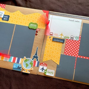 May include: A scrapbook page with a travel theme. It features a yellow, orange, and red color scheme with a variety of travel-themed stickers and embellishments. The page has two photo spaces and a space for writing notes.