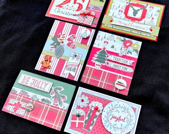 May include: A collection of six Christmas greeting cards with various designs. The cards feature festive elements like reindeer, Christmas trees, and gift boxes. The color palette includes red, green, and white, with text such as "Merry Christmas" and "Be Jolly".