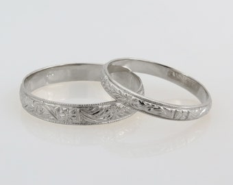 May include: Two silver wedding bands with intricate floral engravings.