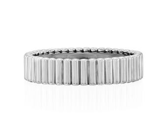 May include: A silver ring with a textured, ribbed design. The ring is made of metal and has a polished finish.