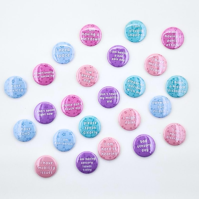 Pastel pinback buttons with a star background and text: I need space, I am having a bad pain day, I have mobility Issues, low energy day, please don't touch me, don't touch my mobility aid, please speak clearly, I can't speak right now, I am non-verbal, I have mobility issues, I am having sensory issues today, bad sensory day, I am hard of hearing, I might faint, please be patient with me, awkward but friendly