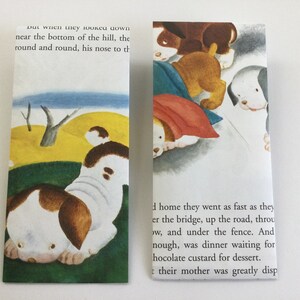 May include: Two bookmarks with illustrations of puppies from a children's book. One bookmark shows a puppy with brown and white markings, while the other shows several puppies. Text from the book is visible.
