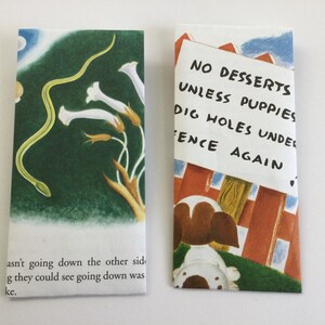 May include: Two illustrated bookmarks. One features a green snake, white flowers, and text. The other shows a puppy and a sign that reads "NO DESSERTS UNLESS PUPPIES DIG HOLES UNDER FENCE AGAIN."