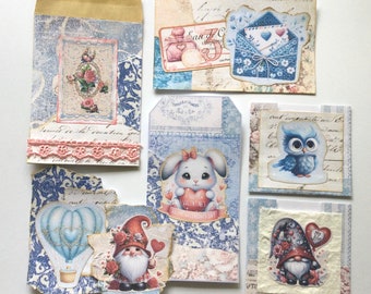 May include: Assortment of vintage-style paper ephemera with a blue and white color scheme. The ephemera features images of a bunny holding a heart, an owl, a gnome, and a hot air balloon. The ephemera also includes text such as "Happy Valentine's Day" and "Sweet Dreams".