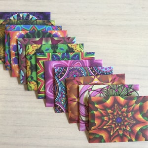 May include: A set of ten colourful envelopes featuring intricate mandala designs. The envelopes are arranged in a fan shape, with the most colourful envelope at the bottom.