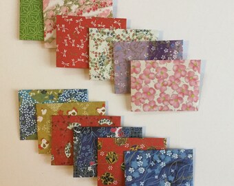 May include: A set of ten colorful patterned paper envelopes. The envelopes are arranged in a staggered pattern, with the top envelope being green and the bottom envelope being blue. The envelopes are all different sizes and shapes, and they are all decorated with different patterns.