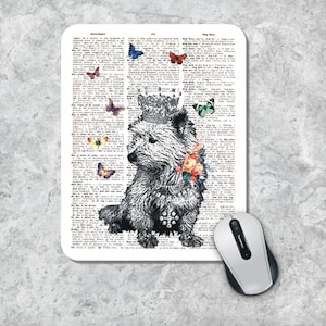 Peut inclure: Une illustration en noir et blanc d'un petit chien portant une couronne et entouré de papillons et de fleurs colorés. L'image est imprimée sur un fond blanc avec un texte de page de dictionnaire.