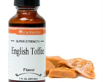May include: A brown glass bottle with a black cap, labeled "LORANN OILS" and "SUPER-STRENGTH- English Toffee Flavor 1 FL. Oz (29.5 mL)". The bottle is next to a pile of light brown toffee candies.