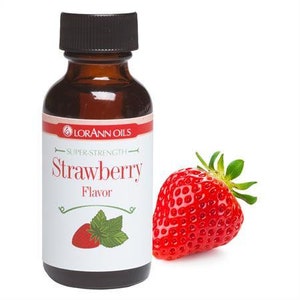 May include: A brown glass bottle with a black cap, labeled "Lorann Oils Super Strength Strawberry Flavor". A red strawberry is in the background.