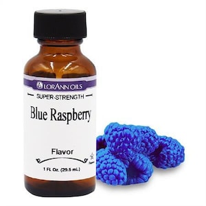 May include: A brown glass bottle with a white label that reads "LORANN OILS SUPER-STRENGTH Blue Raspberry Flavor 1 FL Oz. (29.5 mL)". The bottle is filled with a clear liquid. There are blue raspberries in the background.