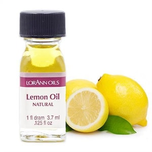 May include: A small glass bottle of lemon oil with a black cap. The bottle is labeled "Lorann Oils Lemon Oil Natural 1 fl dram 3.7 ml .125 fl oz". There are two lemons in the background.