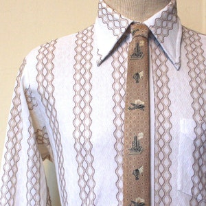 May include: A white long-sleeved shirt with brown vertical stripes and a brown patterned tie. The shirt has a geometric pattern and a pocket on the left side.