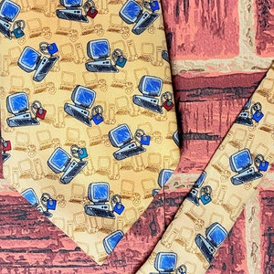May include: Two yellow silk ties with a repeating pattern of blue and black computer monitors with a padlock on each. The ties are on a red and brown brick background.