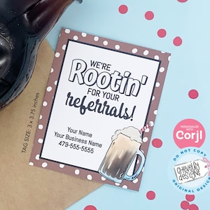 Może przedstawiać: Brązowa karta w białe kropki z tekstem "We're Rootin' for your referrals!" i kresk&oacute;wkową ilustracją napoju z lodami. Karta zawiera miejsce na imię, nazwę firmy i numer telefonu. Karta ma rozmiar 7,62 cm x 9,53 cm.
