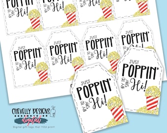May include: Nine printable gift tags with a popcorn design. The tags are white with black text that reads "Just Poppin' By to Say Hi!" and a cartoon image of a red and white striped popcorn bucket with popcorn spilling out.