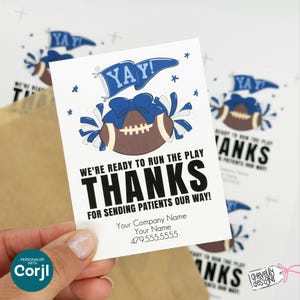Pode incluir: Cartão branco com um gráfico de futebol americano, detalhes azuis e os textos "YAY!" e "THANKS." O cartão inclui também as frases "WE'RE READY TO RUN THE PLAY" e "FOR SENDING PATIENTS OUR WAY!" com informações de contato.