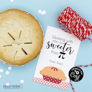 May include: A mini pie in a foil tin next to a gift tag with the text "Working with you is sweeter than &pi;". The tag also has a pie graphic and red and white twine. White confetti dots the light blue background.