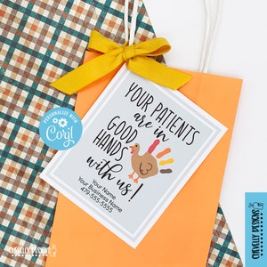 May include: A Thanksgiving-themed gift tag with a turkey illustration and the text "Your patients are in good hands with us!"  The tag is printed on white cardstock with a gray background and has a space for a business name and phone number.