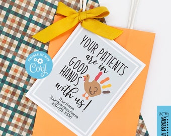 May include: A Thanksgiving-themed gift tag with a turkey illustration and the text "Your patients are in good hands with us!"  The tag is printed on white cardstock with a gray background and has a space for a business name and phone number.