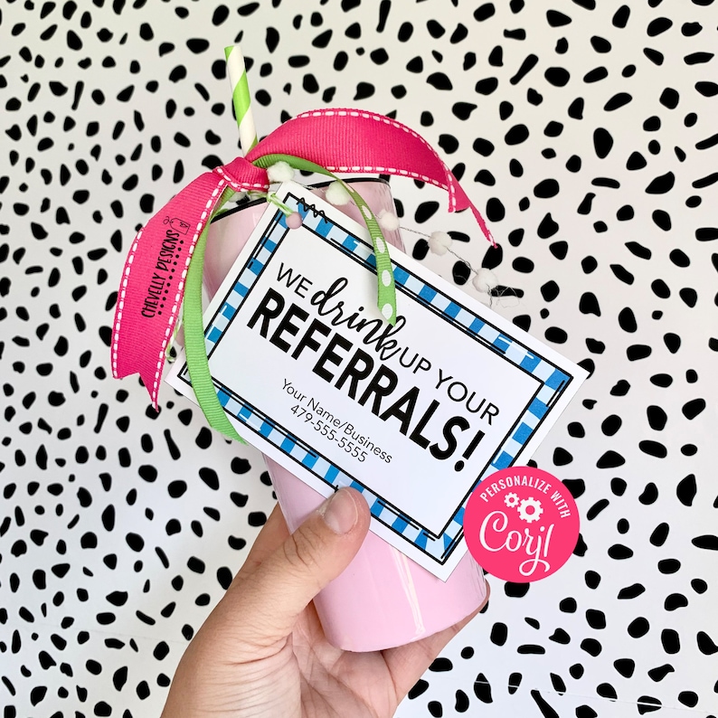 May include: Pink tumbler with a green and white striped straw, pink and white ribbon, and a blue and white checked tag that says "We drink up your referrals!" with a personalised logo that says "Personalize with Corijl".