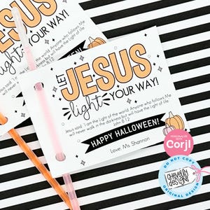 May include: A white card with a black and white striped background. The card has a pumpkin and the text "Let Jesus light your way!" in orange and black. The text "Jesus said, 'I am the light of the world. Anyone who follows Me will never walk in the darkness but will have the light of life.' John 8:12" is in black text. The card also has the text "Happy Halloween!" in black text with a black banner. The text "Love, Ms Shannon" is in black text. The card has a pink glow stick attached to it.