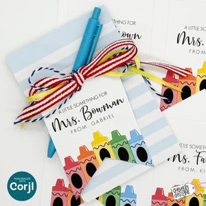 May include: A collection of gift tags and cards with a crayon theme. The tags read "A Little Something For Mrs. Bowman" and "A Little Something For Mrs. Farr". A blue pen and a red, white, and yellow ribbon are included.