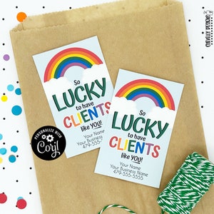 Puede incluir: Dos tarjetas de agradecimiento con temática de arcoíris con el texto "So Lucky to have Clients like you!" y espacio para personalizar con un nombre y un número de teléfono.
