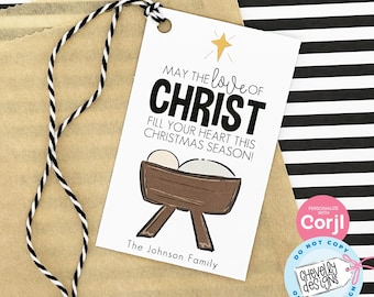 May include: White gift tag with a black and white striped background. The tag features a hand-drawn illustration of a manger with a baby inside. The text reads "May the love of Christ fill your heart this Christmas season!" and "The Johnson Family".
