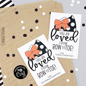 May include: Two printable gift tags featuring a black and white polka dot bow and the text "You are loved from bow to toe!" One tag has the text "Love, Cowboys Football Team" and the other tag has the text "Love, Your Cowboys Football Team".