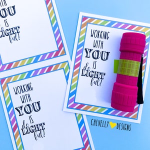 Puede incluir: Dos tarjetas imprimibles con un borde rayado de colores y el texto "Trabajar contigo es luminoso!" Una tarjeta tiene una linterna rosa a su lado. El texto "Chevelly Designs" está en la parte inferior de la tarjeta.