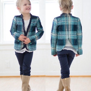 May include: A blue and white plaid blazer with a ruffled collar and long sleeves. The blazer is worn over a white shirt and paired with dark blue jeans and brown boots.