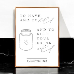 May include: A rectangular sign in a thin metallic frame featuring black text that reads TO HAVE AND TO hold AND TO KEEP YOUR DRINK cold and PLEASE TAKE ONE! with a line drawing of a beverage can cooler featuring a small heart outline.
