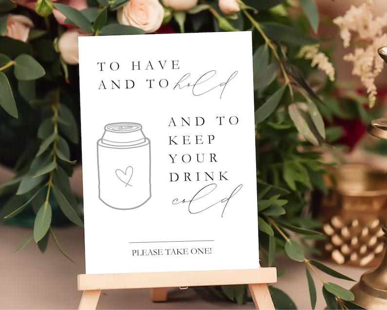 May include: A white rectangular sign with black text that reads TO HAVE AND TO hold AND TO KEEP YOUR DRINK cold and PLEASE TAKE ONE! The sign features a line drawing of a beverage can cooler with a small heart outline on the front surface.