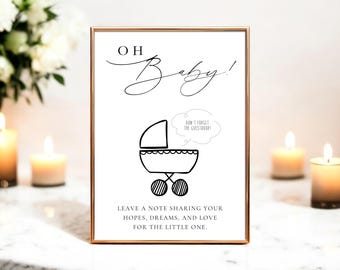May include: A framed sign with the words "OH Baby!" in elegant script, featuring a line drawing of a baby carriage. The sign includes the text "DON'T FORGET THE CUESTROONI" and a message to share hopes and dreams for the little one.