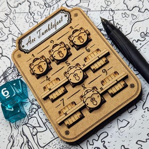 Peut inclure: Un plateau de jeu en bois avec le nom "Ace Tumblefoot". Il comporte des curseurs en forme de cadenas et des marquages numérotés. Deux dés bleus et un stylo noir sont également visibles. Le fond est une carte en noir et blanc.